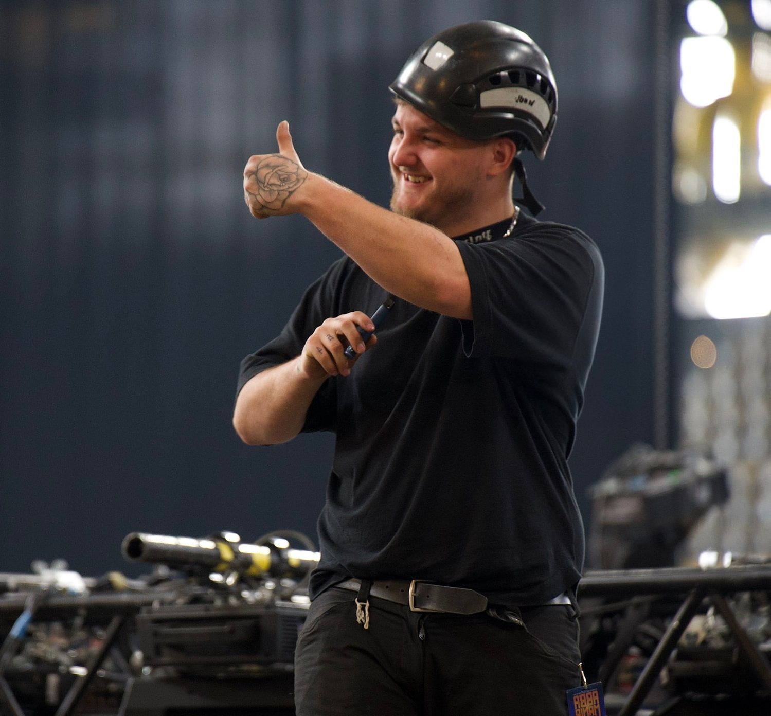 Glücklicher Mitarbeiter mit Helm zeigt einen Daumen nach oben.