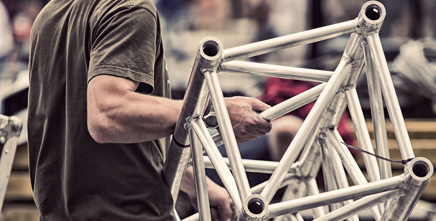 Nahaufnahme von einem Mitarbeiter, welcher ein Bühnengerüst trägt.